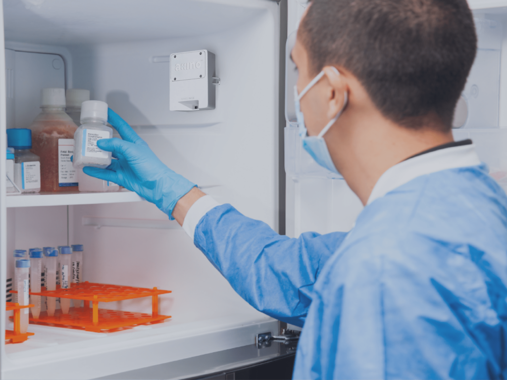 A man wearing gloves pulling medicine out of a cooler